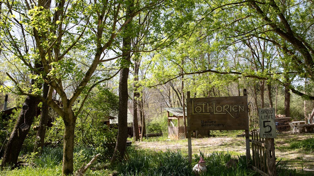 A hand-painted sign reads “Lothlorien Nature Sanctuary” on May 1, 2022, at the entrance of the 121 acre patch of forested land near Judah, Indiana. The community is home to a handful of full-time residents and more than 400 members.
