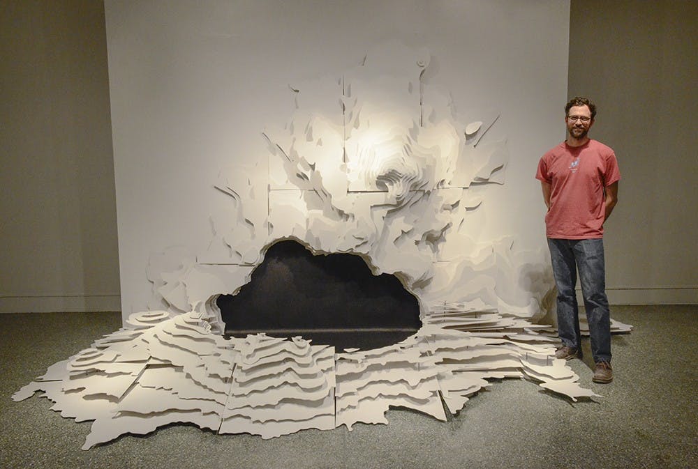 Tai Rogers, MFA Ceramics at the School of Fine Arts, showcases the largest piece among the three of his "Fabricated Landscapes" project that he spent three months to build during the School of Fine Arts MFA Thesis Exihibitions in the Grunwald Gallery of Art on Wednesday. Rogers' inspiration was from maps - he used his imagination to make the lines more vivid than a flattened world. 
