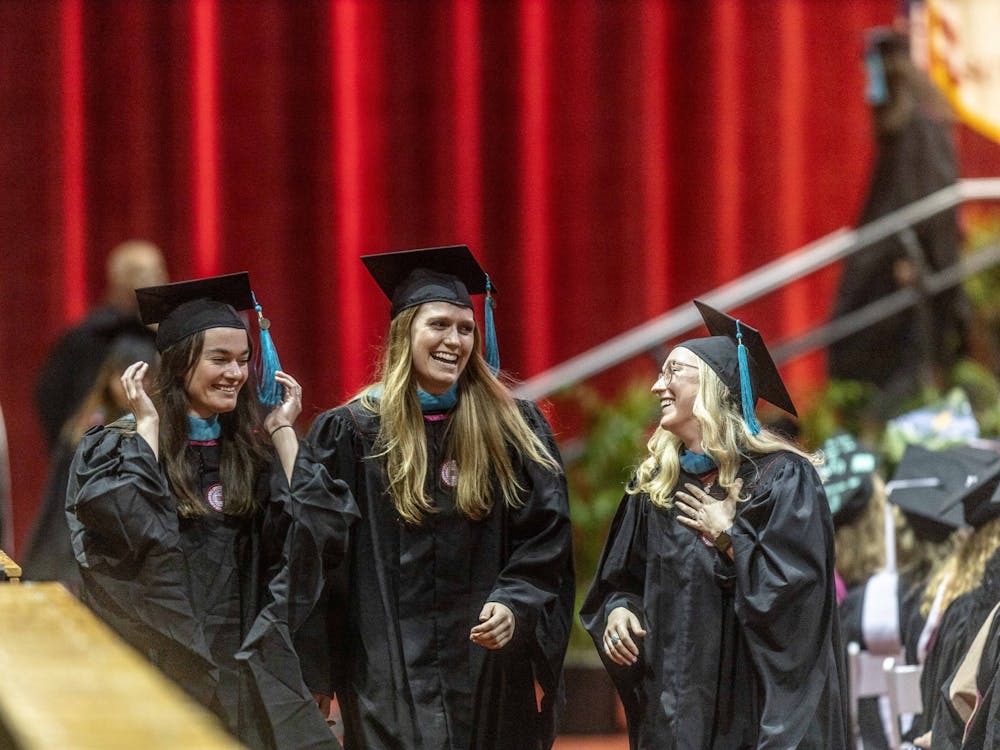 A group of graduates laugh while heading back to their seats after walking across the stage May 6, 2022, in Simon Skjodt Assembly Hall. While all graduates walked, only doctoral degree recipients had their names announced.