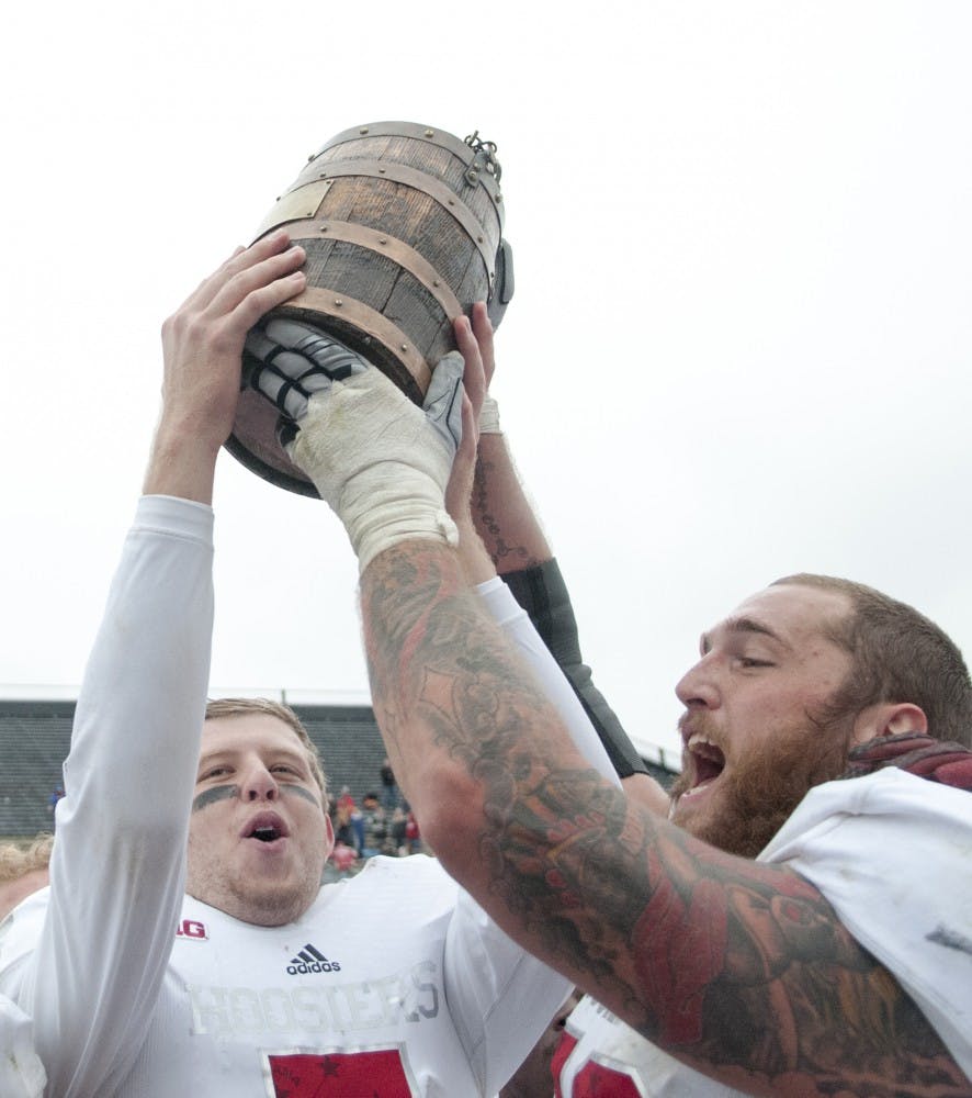 Senior quarterback Nate Sudfeld and senior linebacker Jason Spriggs hoist the Oaken Bucket after beating Purdue, 54-36 on Saturday at Ross-Ade Stadium.