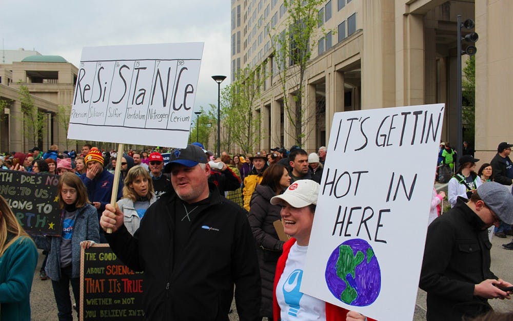 Carey and Keith Gaskill, Indianapolis residents, hold up their signs before the March for Science begins on Saturday morning. Keith is a local geochemist. 