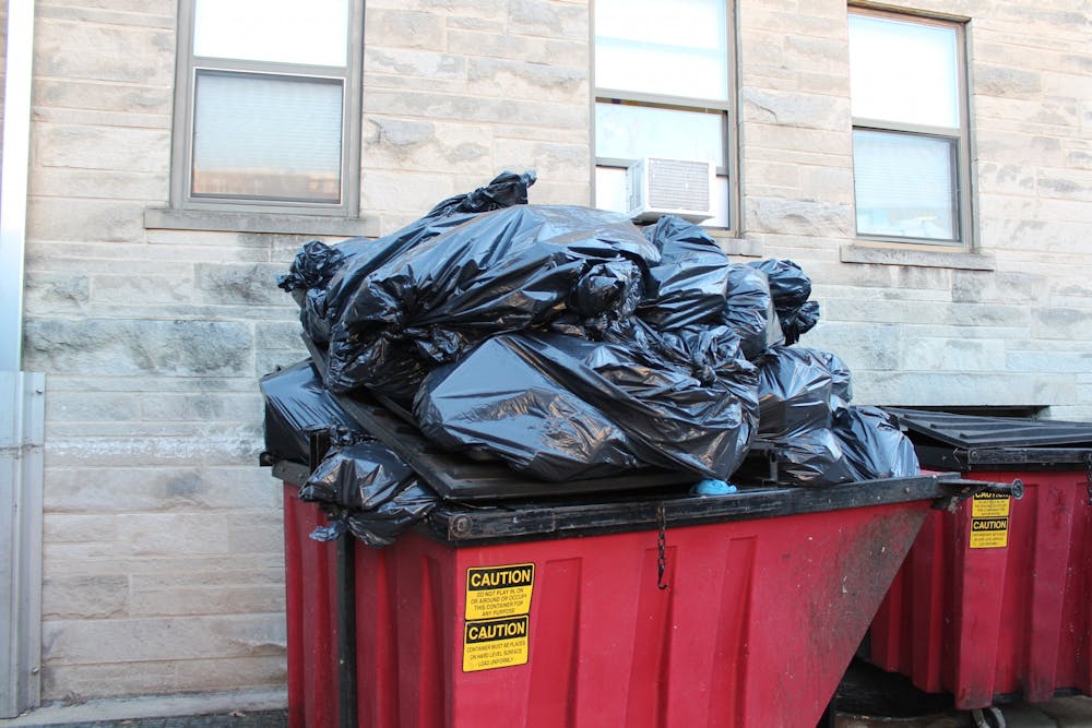 <p>A tower of black garbage bags full of trash fills a red dumpster on Feb. 20, 2023 outside of the Wright Quad dining hall. Because roughly 10% of Bloomington’s recycling is contaminated by non-recyclables, it ends up being sent to dumpsters.</p><p> </p>