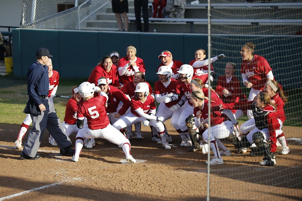 Members of the IU Softball team celebrate after freshman Mena Fulton hit a 3-run home run during the last inning of IU's game against Purdue Wednesday at the Andy Mohr Field; resulting in a 6-3 win for the hoosiers. 