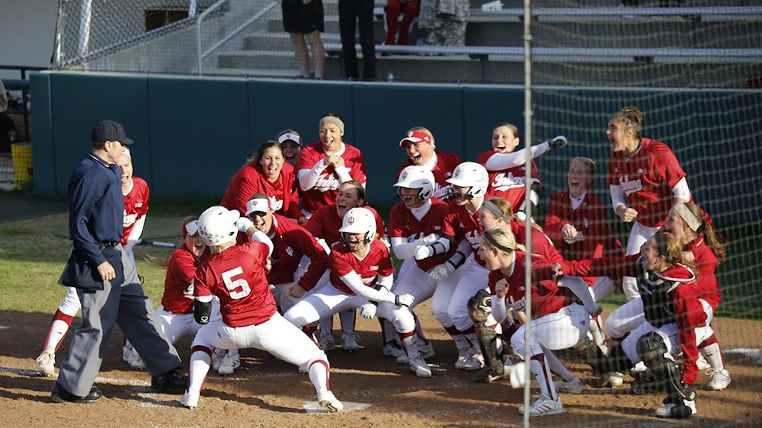 Members of the IU Softball team celebrate after freshman Mena Fulton hit a 3-run home run during the last inning of IU's game against Purdue Wednesday at the Andy Mohr Field; resulting in a 6-3 win for the hoosiers. 