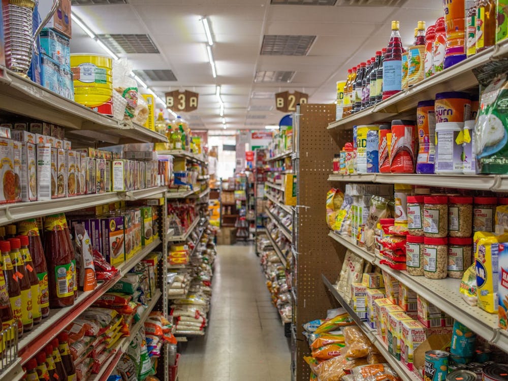 The aisles of Apna Bazaar, an Indian-owned grocery store on Third Street, are shown with products on the shelves. 