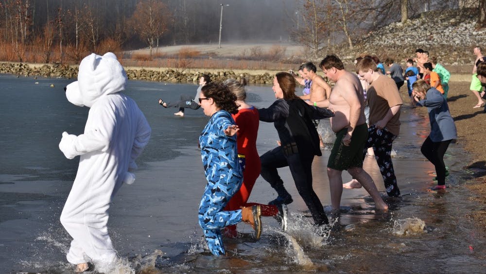 Polar Plunge participants dash toward icy waters at Lake Monroe. The annual event raises money for the Boys &amp; Girls Clubs of Bloomington.