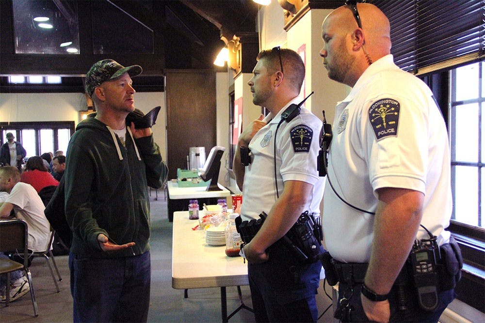 Jamie Voci (left), a local transient man, greets officers Brett Rorem and Robert Skelton as they monitor a free breakfast at First Christian Church. Voci said the officers helped him straighten out after issues with drugs and alcohol, and frequent run-ins with the law.