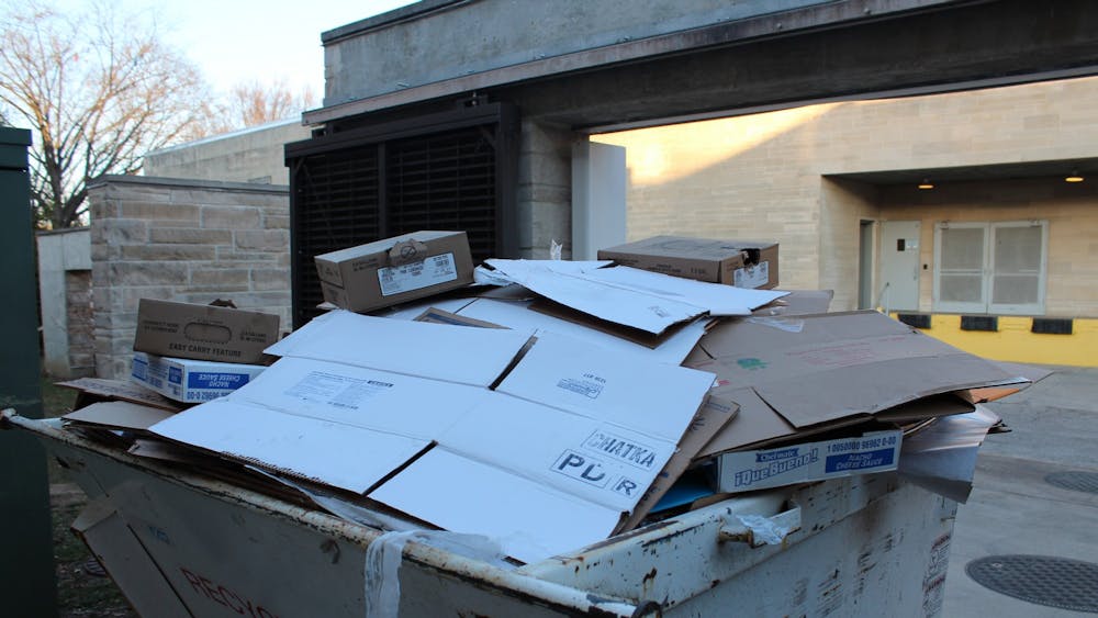 Cardboard material is thrown into a separate dumpster for recyclables only outside of the Wright Quad dining hall on Feb. 20, 2023. According to Protect IU, IU-Bloomington produces 45 tons of hazardous waste. 