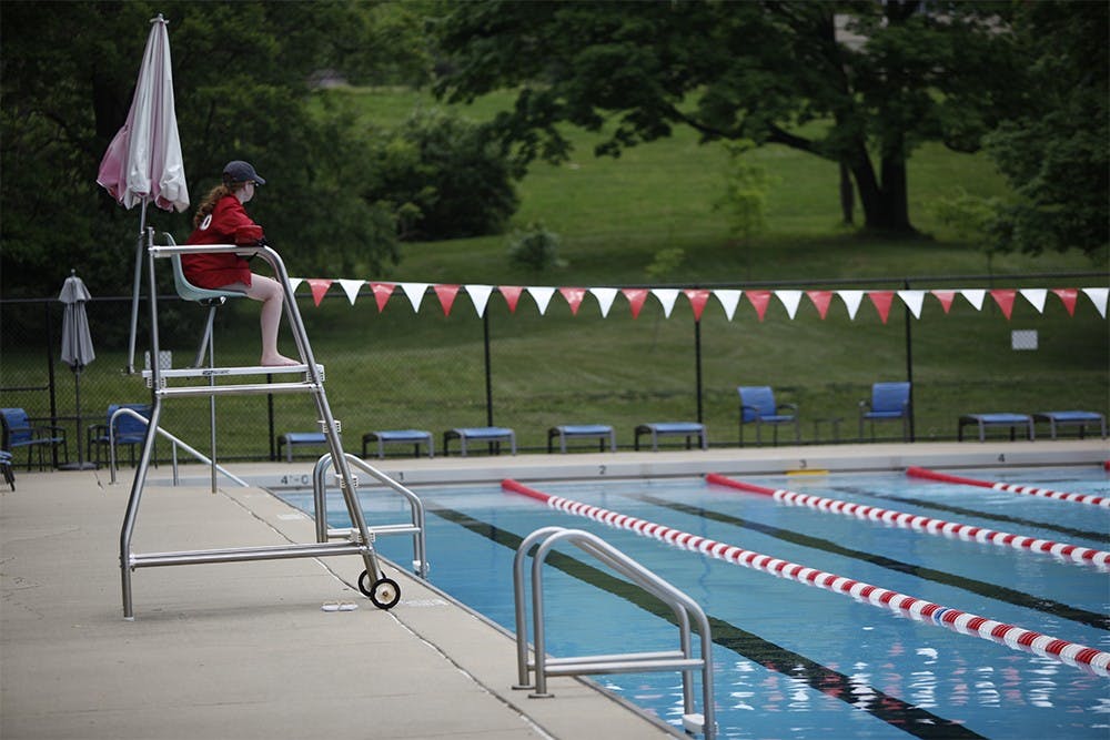 Lifeguard Amanda Viscardi overlooks swimmers in the 50 meter pool at the IU outdoor pool on Wednesday.  The pool is open mid-day for "Warm Up Days", but will not reopen for the regular season until May 23.