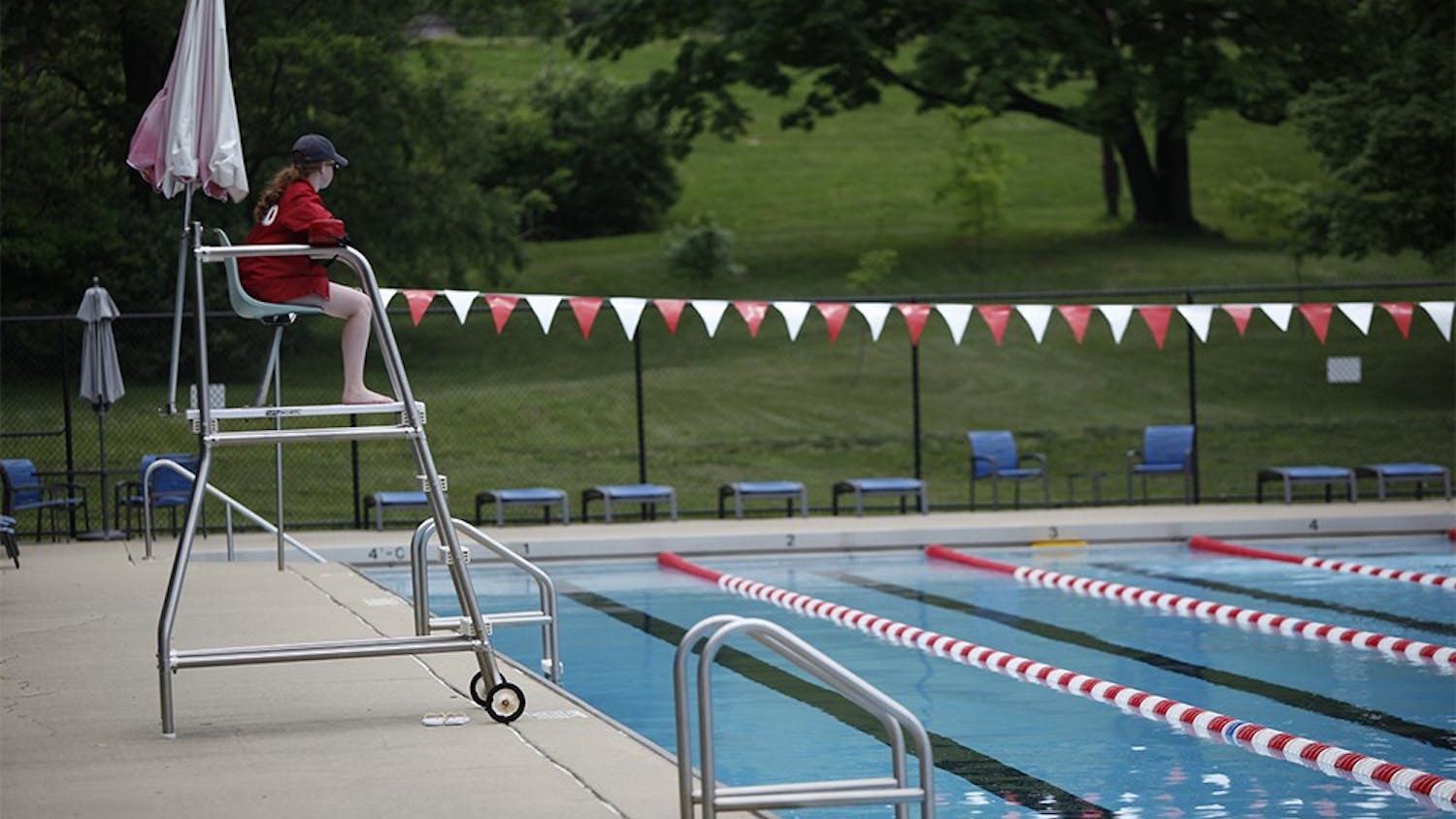Lifeguard Amanda Viscardi overlooks swimmers in the 50 meter pool at the IU outdoor pool on Wednesday.  The pool is open mid-day for "Warm Up Days", but will not reopen for the regular season until May 23.