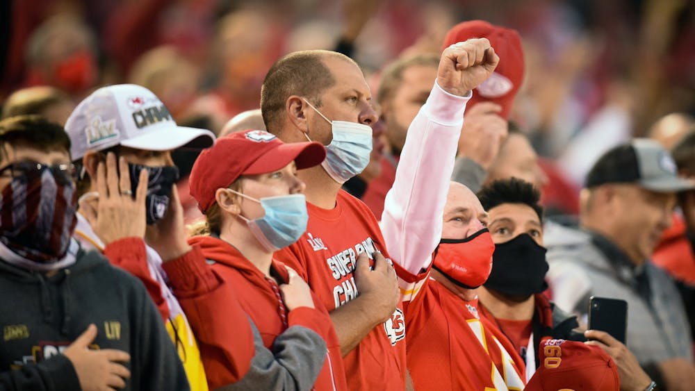 A Kansas City Chiefs fan raises a fist during the national anthem at the Chiefs' home opener Thursday against the Houston Texans at Arrowhead Stadium in Kansas City, Missouri.