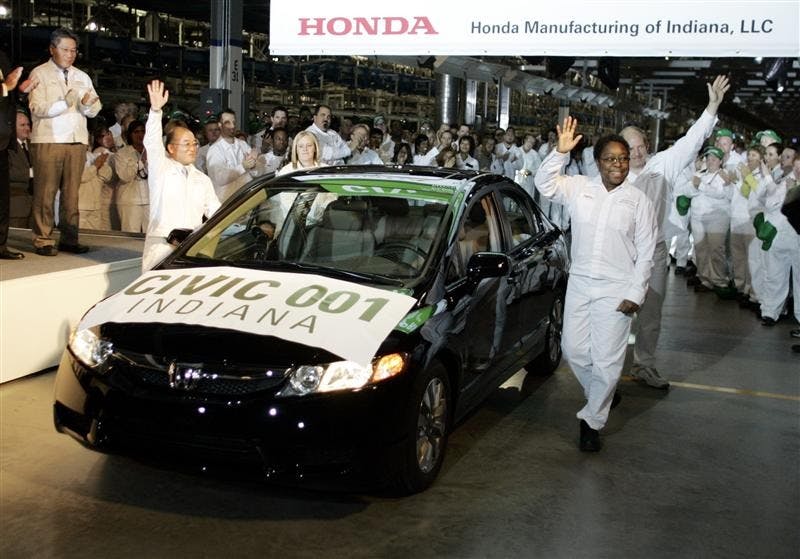 Daphna Tubbs, front right, of Greensburg, Ind., waves after driving the first Honda Civic produced in Indiana off the assembly line at the Honda assembly plant on Monday in Greensburg, Ind. The plant, which began producing the Honda Civic Sedan last month, was dedicated on Monday.