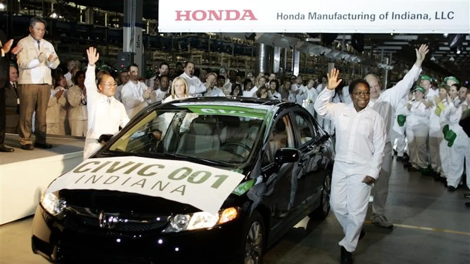Daphna Tubbs, front right, of Greensburg, Ind., waves after driving the first Honda Civic produced in Indiana off the assembly line at the Honda assembly plant on Monday in Greensburg, Ind. The plant, which began producing the Honda Civic Sedan last month, was dedicated on Monday.