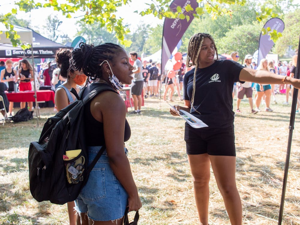 Autumn Stringer, IU junior and Union Board representative, points two students in the direction of the Union Board Booth Aug. 26, 2021, at the Involvement Fair in Dunn Meadow. The Union Board hosts movie nights throughout the school year on Thursdays, Fridays and Saturdays.