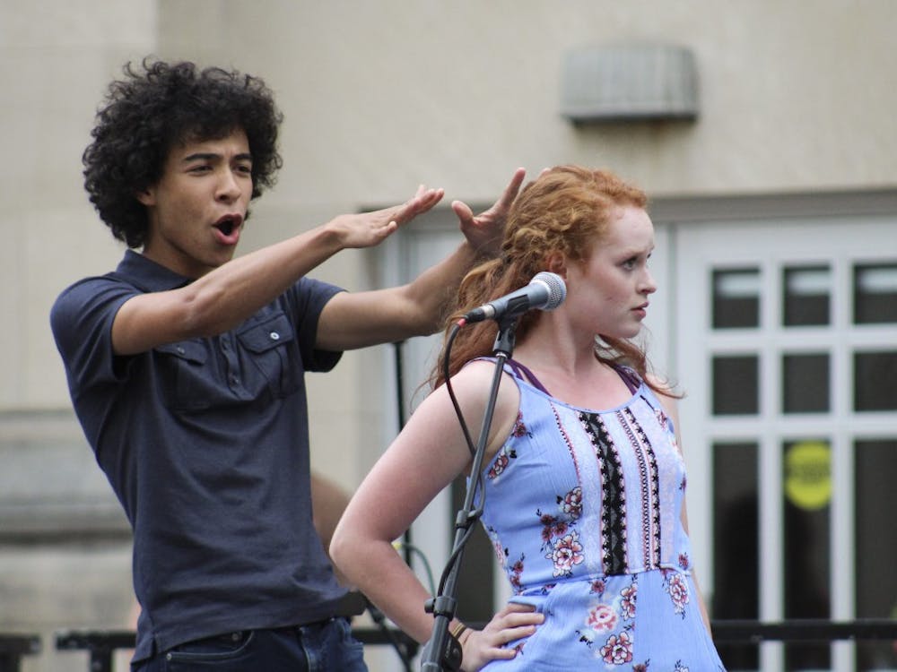 Sophomore Ethan St. Germain, left, and junior Katie Swaney, right, perform for the First Thursdays festival with Outreach Cabaret on Thursday evening at the Fine Arts Plaza.&nbsp;