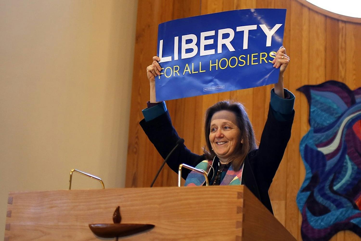 Reverend Mary Ann Macklin holds up a sign made by the organization "Freedom Indiana" to show her opposition to Governor Mike Pence's recent decision to sign the Religious Freedom Reformation Act during the 9:15 church service at the Unitarian Universalist Church of Bloomington, the Sunday after the bill was signed. 