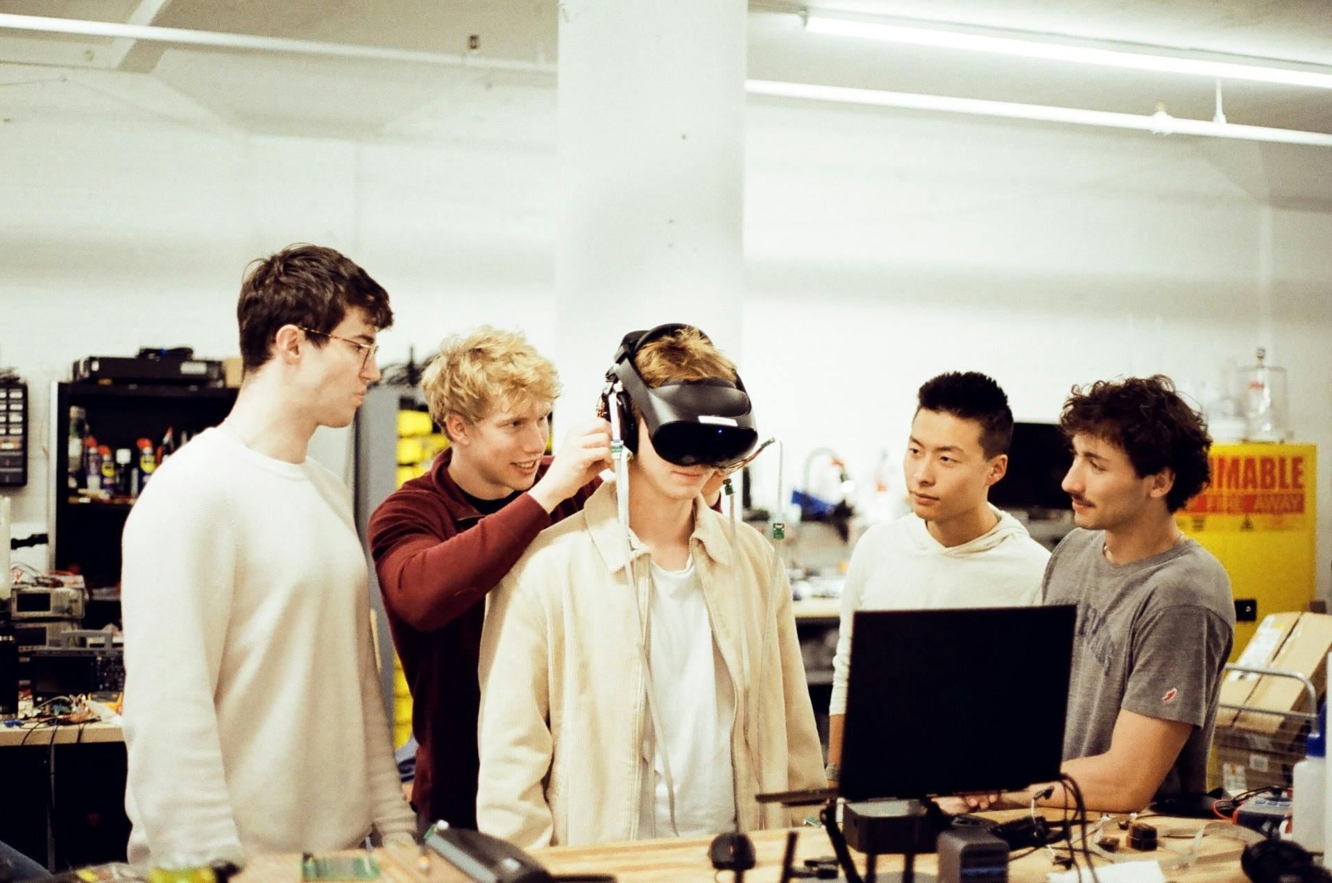 COURTESY OF VINCENT COLÓN
Orbit members Khrapko (far left), Green (second to the left), Pang (second to the right) and El-Habr (far right) gathered around a visitor who is wearing one of Orbit’s headsets.&nbsp;