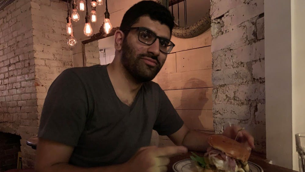 COURTESY OF JERRY WU
Wu’s co-reviewer pointing to the legendary Duke’s Grocery Proper Burger.