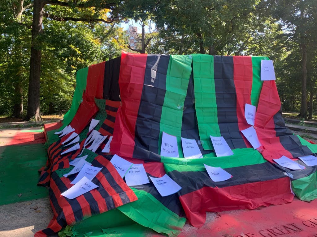 COURTESY OF HELEN LACEY
Attendees taped the names of those who were enslaved on the Homewood campus to the pan-African flag to honor their lives and legacies.