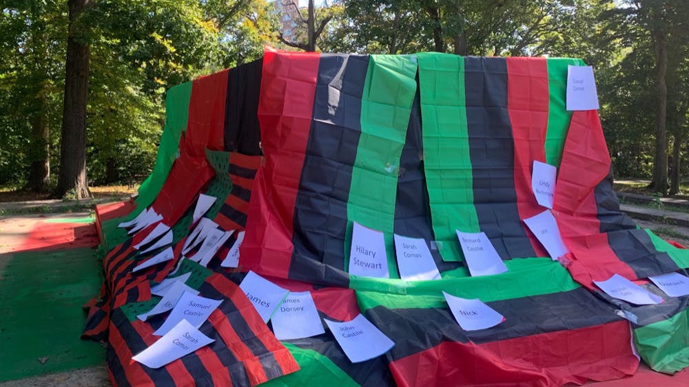 COURTESY OF HELEN LACEY
Attendees taped the names of those who were enslaved on the Homewood campus to the pan-African flag to honor their lives and legacies.