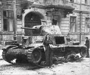  PUBLIC DOMAIN
A courier poses in front of a badly damaged Italian tank after the first several days of the Warsaw Uprising.
