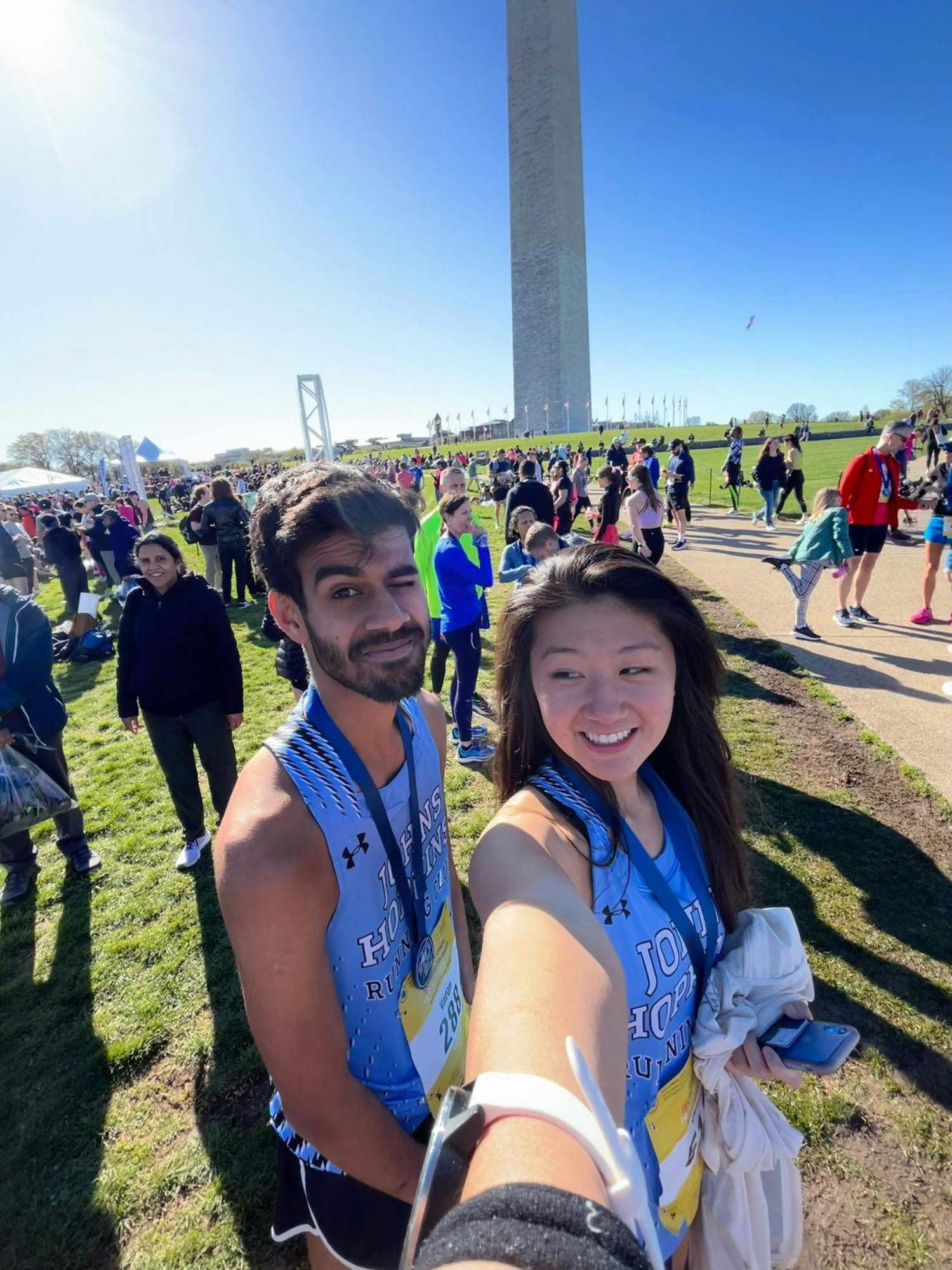 COURTESY OF JULIA WANG
Julia at the finish line near the Washington Monument, sporting her medal and the Hopkins running club gear.&nbsp;