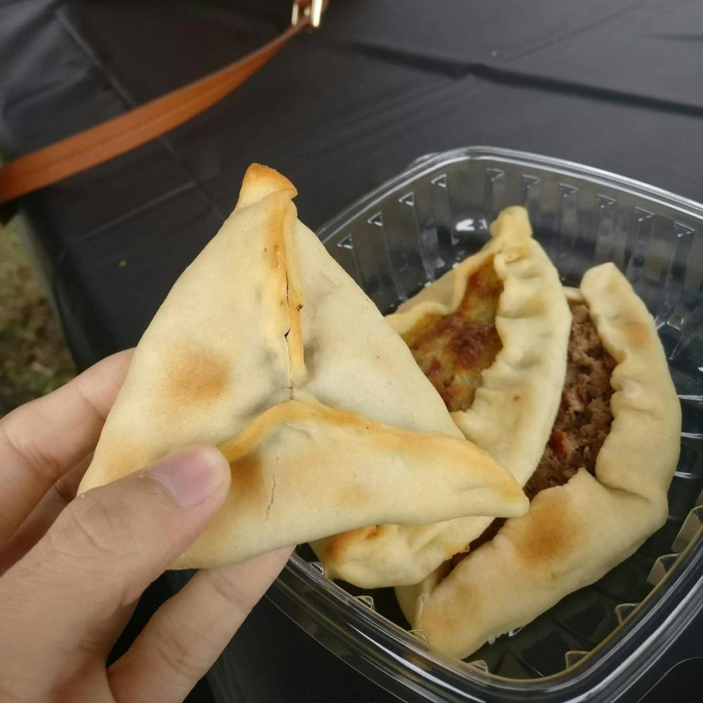 COURTESY OF JESSE WU&nbsp;
Trying fatayer, a Middle Eastern meat/cheese/spinach pie, at the festival.