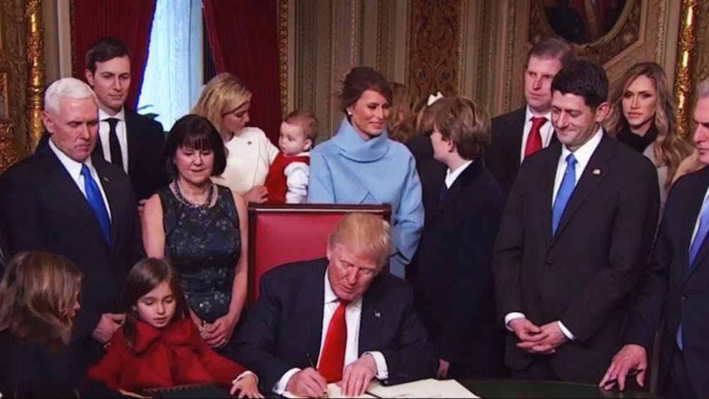Karl-ludwig poggemann/cc by 2.0
President Donald Trump signs a stack of executive orders on Inauguration Day.