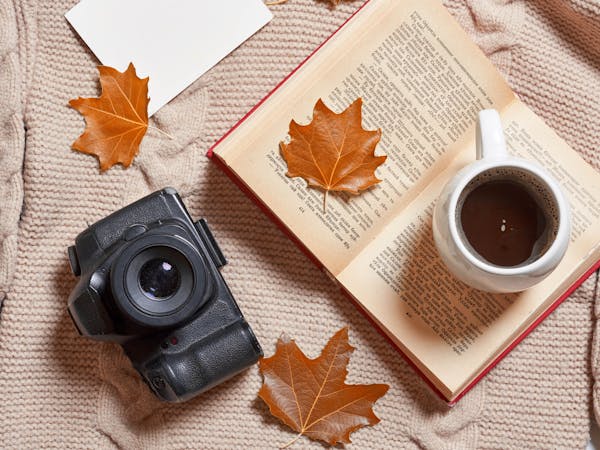 Fall leaves, warming sweater, cup of coffee, book and photo came
