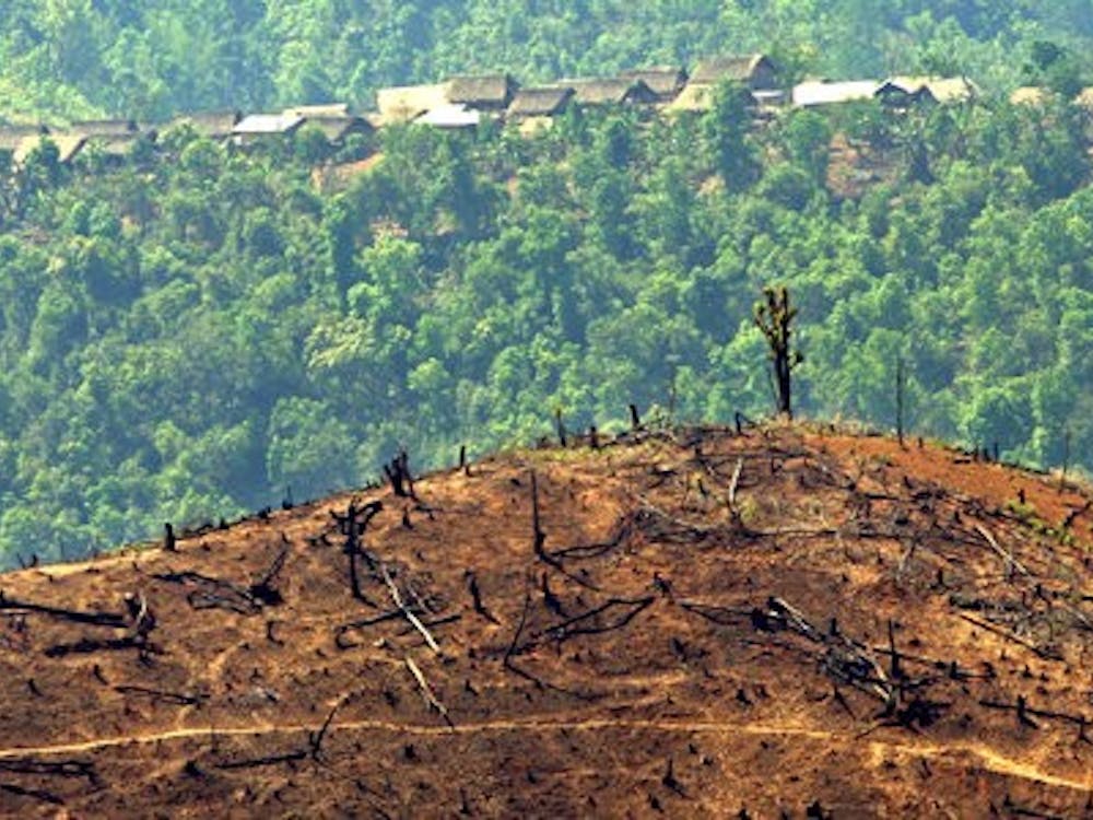 epa00182685 A small village where rice and opium farmers live is seen behind a large hill which has been cleared of timber by slash and burn methods ready for agriculture, in north-eastern Myanmar (Burma), close to the Chinese border, Monday 26 April 2004. Unchecked logging fuelled by the huge growth in the Chinese economy has taken its toll on the area. Deforestation is acute in Myanmar as a consequence of timber exploitation and poor agricultural methods and it is one of the least environmentally protected countries in South East Asia. Myanmar supplies 60 per cent of the world's teak wood consumption, and derives nearly 10 percent of it's foreign income from timber exports. EPA/BARBARA WALTON