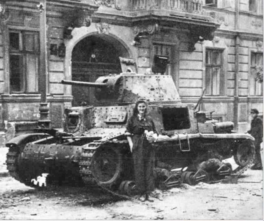 PUBLIC DOMAIN
A courier poses in front of a badly damaged Italian tank after the first several days of the Warsaw Uprising.