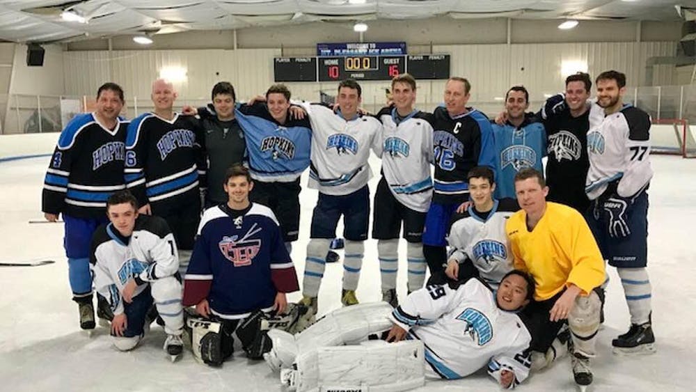 COURTESY OF ANDREW GRAY
Gray (standing, fourth from right) and Bill Dwyer (far left) attend an alumni hockey game in 2018, having started the club in the ‘80s.