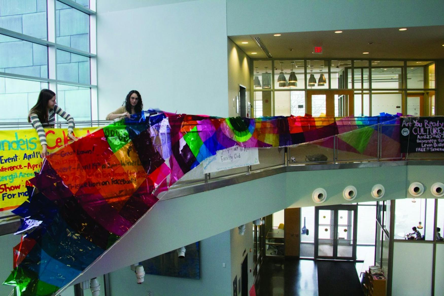RAINBOW CONNECTION: Rachel Berkovitz ’15 (left) and Jess Podhorcer ’15 installed their “Color Theories” yesterday morning. The piece stretches 37 feet long.