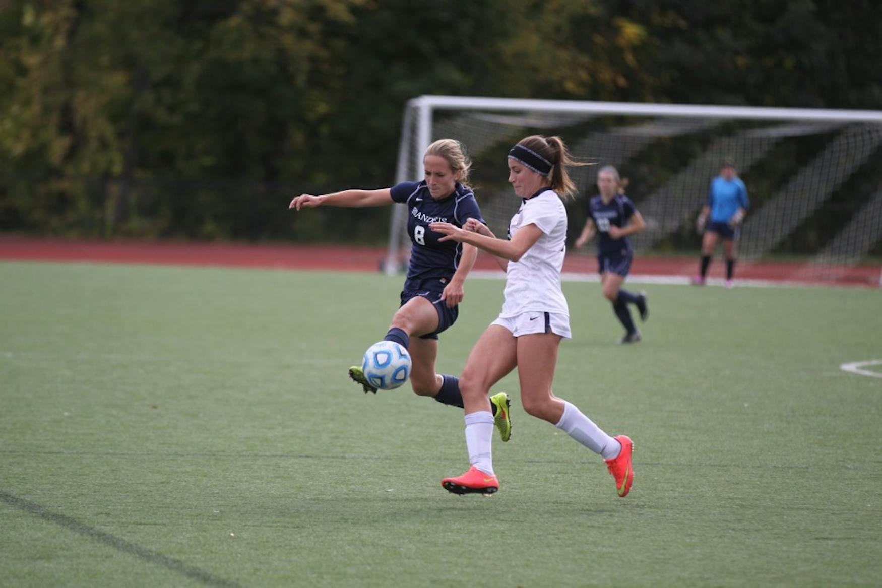 UP IN THE AIR: Forward Haliana Burhans ’18 (left) jumps to gain conrol of the ball from an Emory University defender on Sunday.