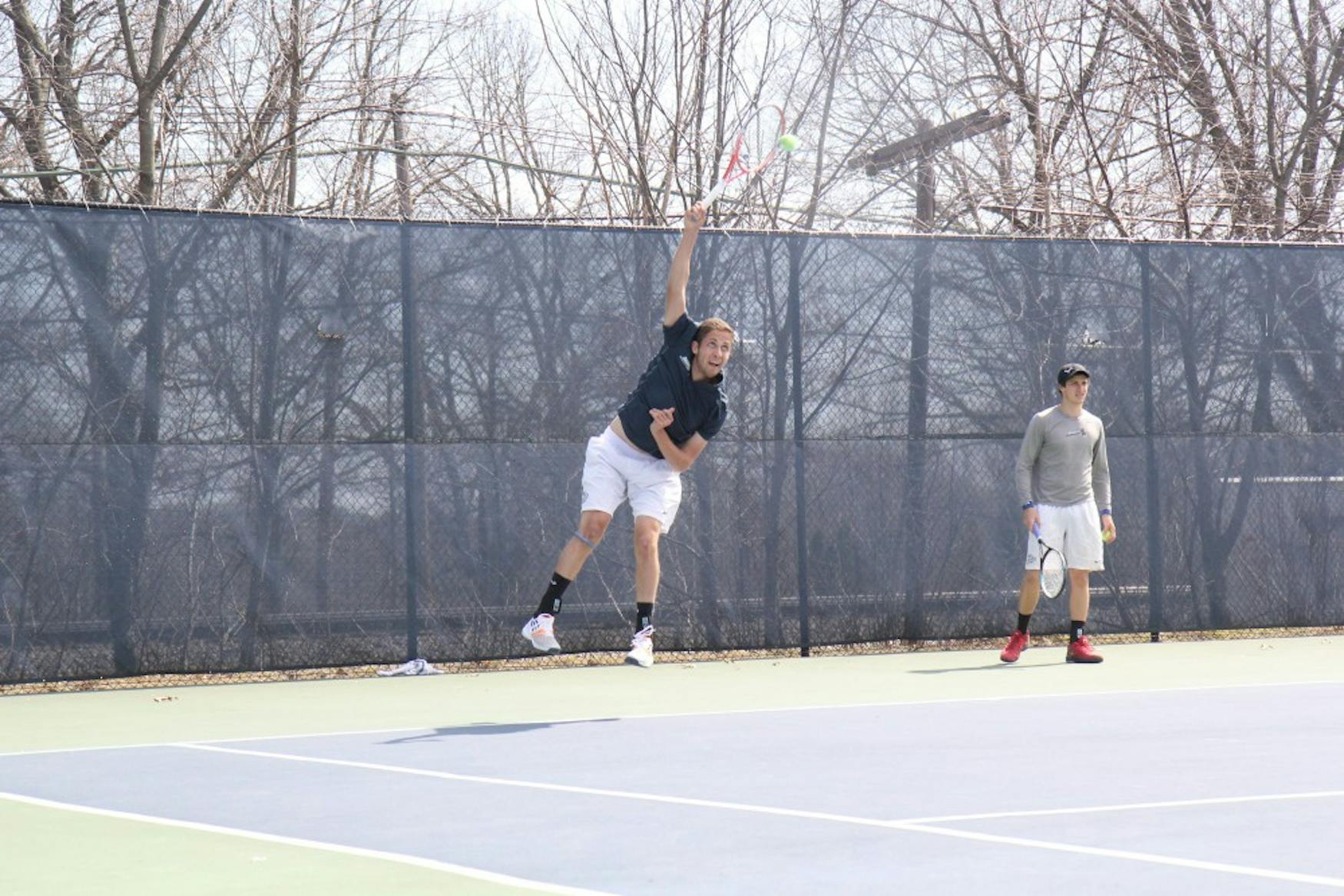 OVERHEAD SLAM: Danny Lubarsky ’16 (left) and Brian Granoff ’17 play in a doubles match against New York University on April 18.