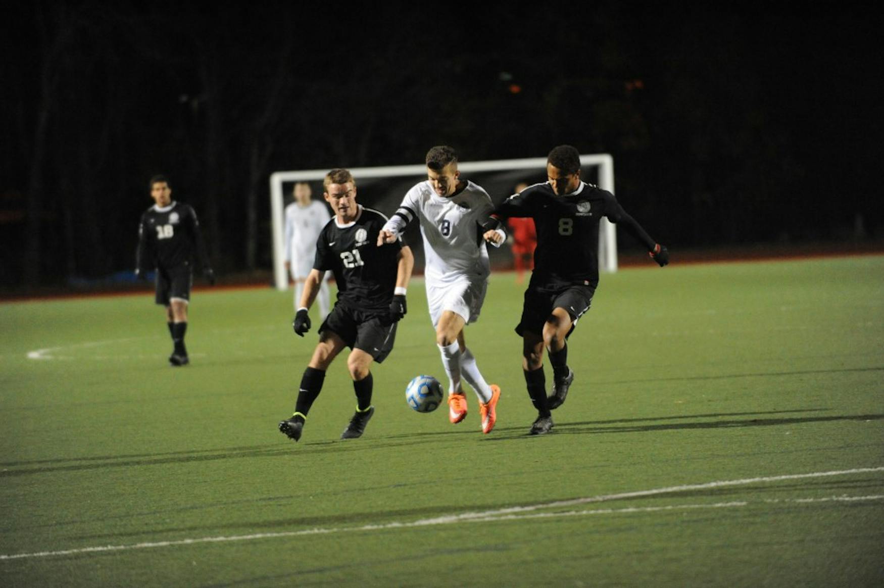 FIRST TOUCH: Forward Tyler Savonen ’15 (center) cuts through two defenders during the team’s 1-0 win against Bowdoin College.