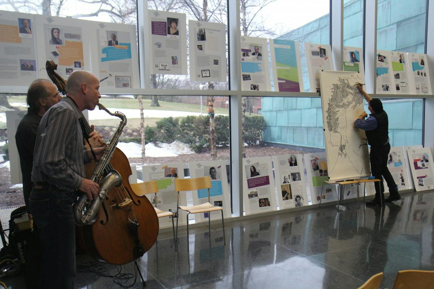 IMPROV TRIO: On Friday afternoon, three artists, Prof. Tom Hall (MUS, left), bassist Marty Ballou (left, back) and artist and musician Lennie Peterson (right) performed together, taking inspiration from each other’s work to create music and a portrait.