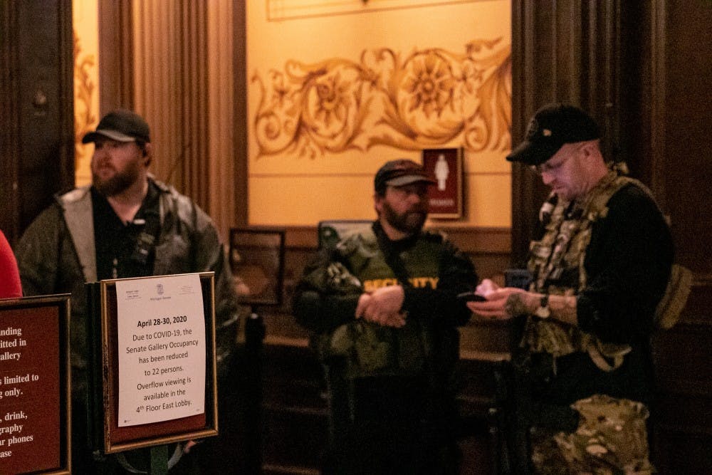 Men in tactical gear stand outside the Senate Gallery due to the limit on occupancy inside at the protest in the Capitol April 30, 2020 in Lansing.