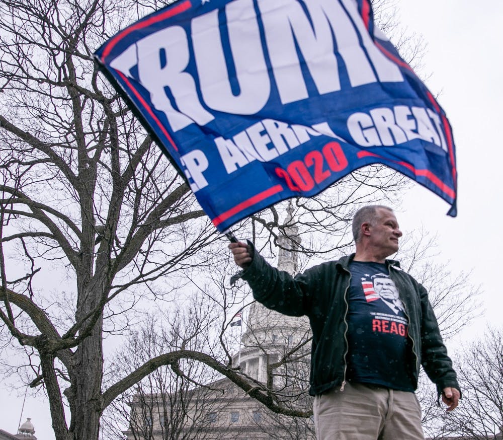 A man waves a Trump flag at the Operation Gridlock protest April 15, 2020 in Lansing.