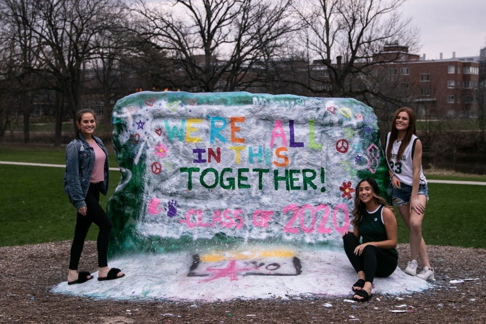 <p>Kelsey Estes, Meghan Provenzano and Abby Henzi (left to right) pose after painting the Rock on Farm Lane April 7, 2020.</p>