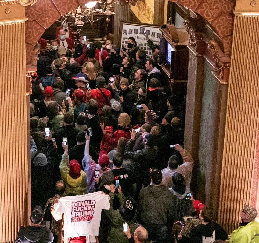 A crowd gathers outside a door to the House floor at the protest in the Capitol April 30, 2020 in Lansing.