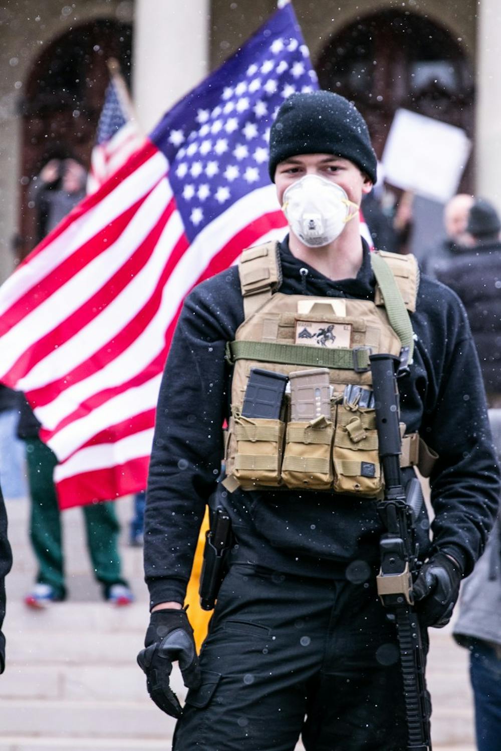 A man holds his gun in front of the Capitol at the Operation Gridlock protest April 15, 2020 in Lansing.