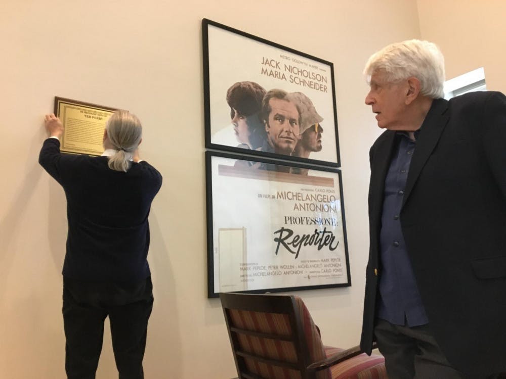 <span class="photocreditinline">WILL DIGRAVIO/THE MIDDLEBURY CAMPUS</span><br />Ted Perry, Fletcher Professor of the Arts Emeritus, beside a plaque hung in Axinn Center in recognition of his contributions to film at Middlebury. He initiated film studies at the college upon his arrival in 1978.