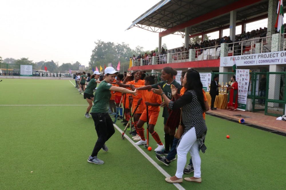 <span class="photocreditinline">COURTESY PHOTO</span><br />Middlebury field hockey coaches and alums high-five a group of young players before a scrimmage in Ranchi.