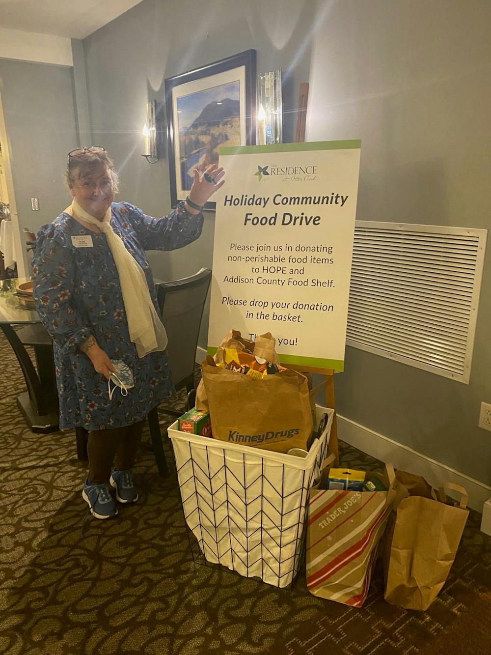 The food drive basket was already overflowing as of Oct. 31. Seen here with Rose Chevalier, the receptionist at The Residence. Photo courtesey of Tracy Van Hoven.
