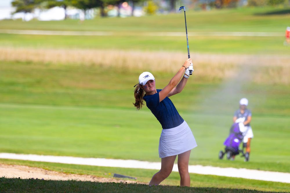 Mia Politano ’25 hits a ball out of the sand trap.