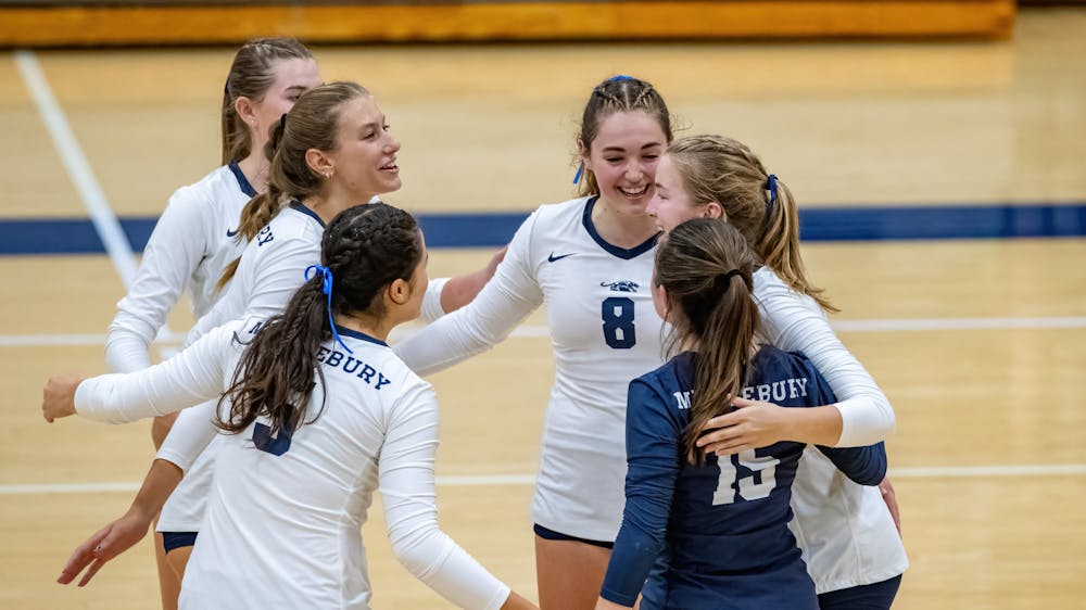 Members of the women’s volleyball team celebrates during a match.