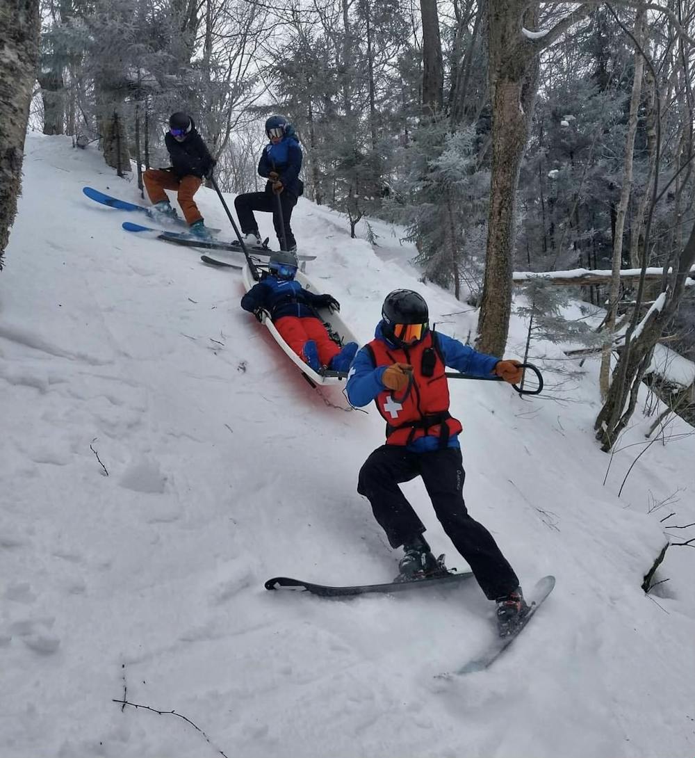 Keegan Leach '25 (front) leads a toboggan during a ski patrol rescue. 