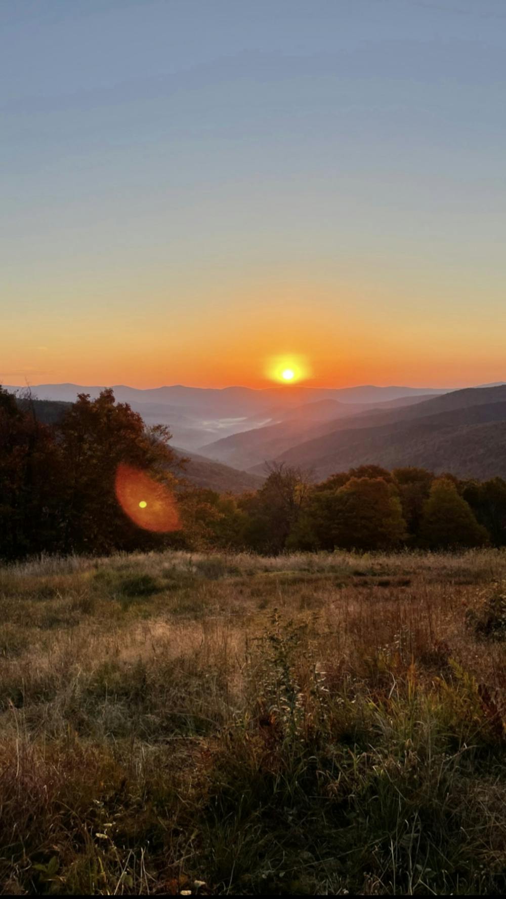 <p>The sun rises over the Middlebury snowbowl during a hike at dawn.</p>