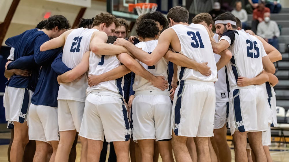 <p>Men’s basketball (19–5) huddles together during their thrilling 89–80 loss to Tufts.</p>